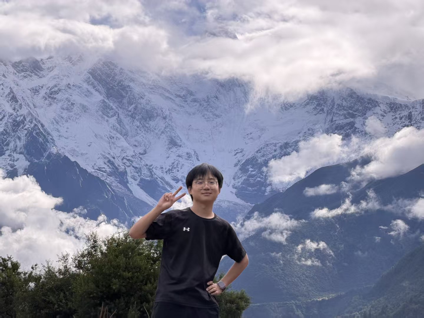 Yujie Liu standing in front of snow-covered mountains